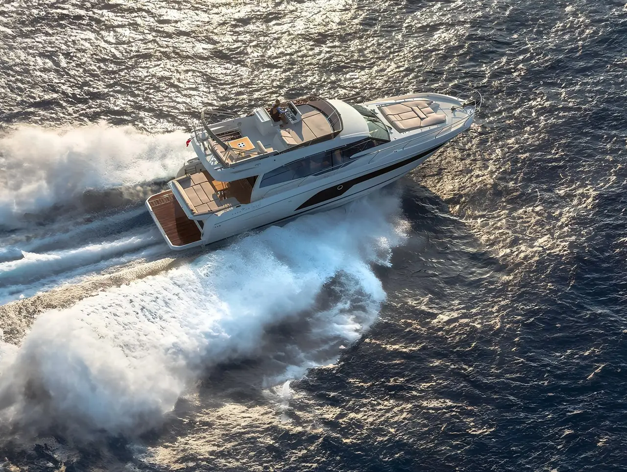 Prestige 590 Fly, aft deck — Barcelona Yacht Rental, Barcelona. Sitges coves by day, flybridge sunsets by dusk