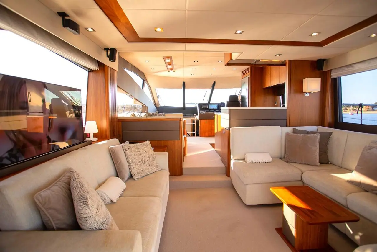 Manhattan 65, pont principal — Barcelona Yacht Rental, Barcelone. Cap sur Sitges, flybridge ouvert, sillage franc l'après-midi